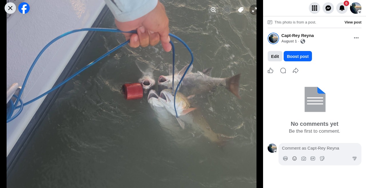 Angler holding a fresh redfish catch on the Laguna Madre with Capt. Rey