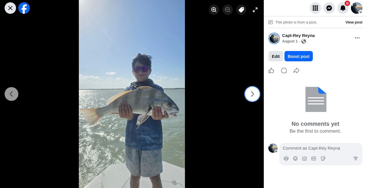 Young angler smiling with a redfish on the boat